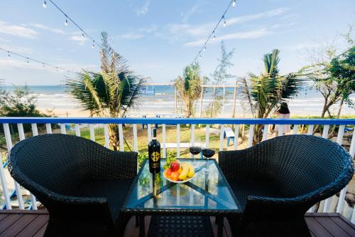 a table with a bowl of fruit on a balcony with the beach at Lee House Villa Tam Thanh in Tam Ky