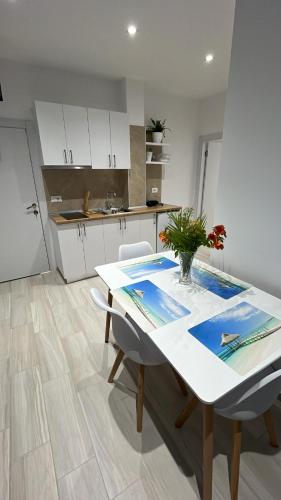 a kitchen with a table with a vase of flowers on it at Vila Luani in Vlorë