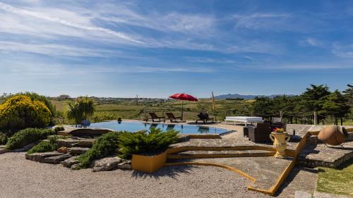 a swimming pool in a yard with a red umbrella at Kochab Sintra by LovelyStay in Sintra