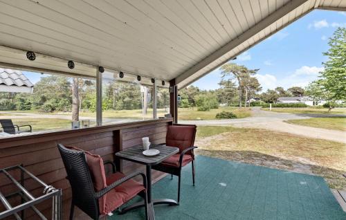 a screened in porch with a table and chairs at Beautiful Home In Nexø With Kitchen in Neksø