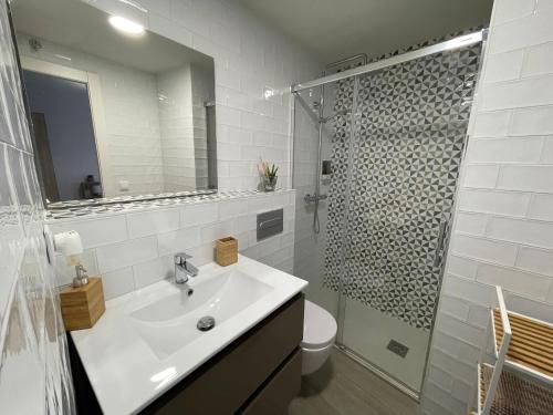 a white bathroom with a sink and a shower at Carmen Alta in Tudela