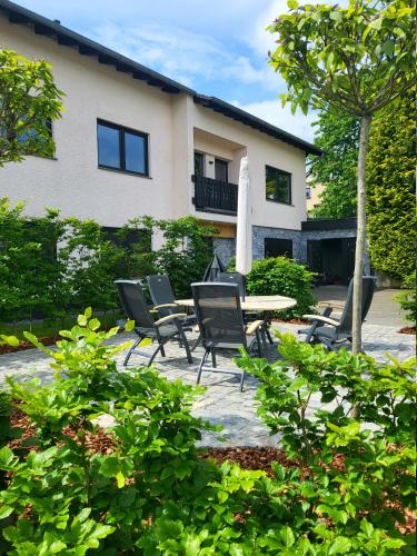 a patio with chairs and a table in front of a building at Einzigartige Traumwohnung mit Whirlpool & Sauna bietet Luxus und Erholung in Neuheilenbach