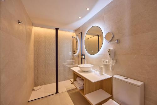 a bathroom with a sink and a toilet and a mirror at Universal Hotel Bikini in Cala Millor