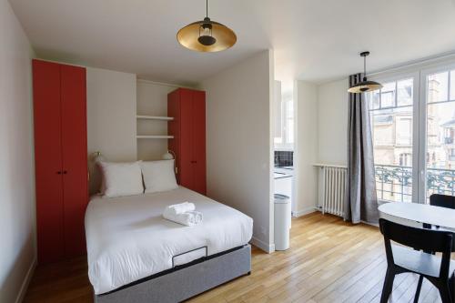une petite chambre avec un lit et une table dans l'établissement The Paris 15 Place, à Paris