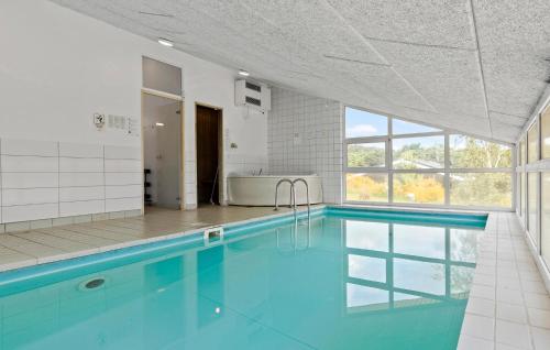 a large swimming pool with blue water in a bathroom at Beautiful Home In Ebeltoft With Wifi in Ebeltoft