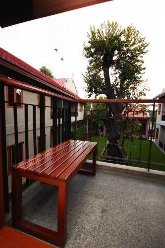 a wooden bench sitting on the side of a building at Chu Hotel in Chiang Mai