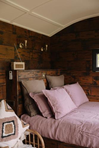 Ce lit se trouve dans un dortoir doté de murs en bois. dans l'établissement The Piggery - luxe hut retreat, à Levaré