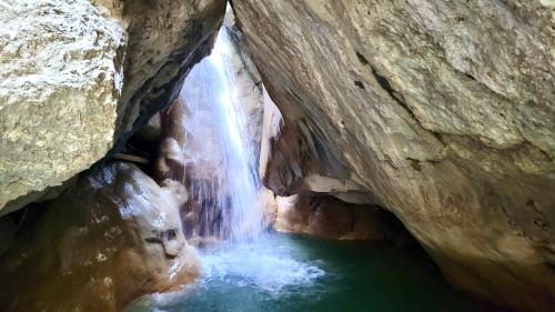a waterfall in a cave next to a pool of water at Costas Inn in Spílion