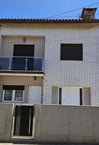 a brick building with two windows and a cross on it at Casa da Praia in Póvoa de Varzim