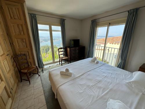 une chambre avec un grand lit blanc et un balcon dans l'établissement Maison de charme vue mer 5chambres Théoule sur mer, à Théoule-sur-Mer