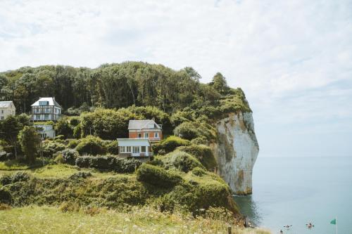 a house on a cliff next to the water at Huttopia Les Falaises - Normandie in Saint-Pierre-en-Port