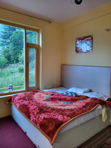 En eller flere senge i et værelse på Himachali Didi Homestays