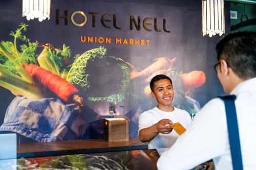 a man sitting at a table in front of a store at Hotel Nell - Union Market in Washington