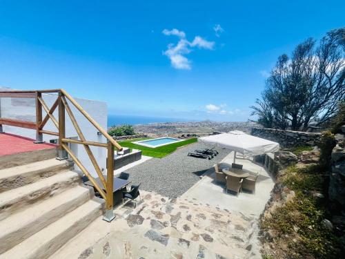 a patio with a white umbrella and a pool at Villa Alegría Gran Canaria Piscina Climatizada in Las Palmas de Gran Canaria