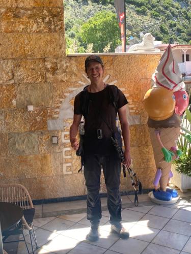 a man is standing next to a balloon statue at Costas Inn in Spílion