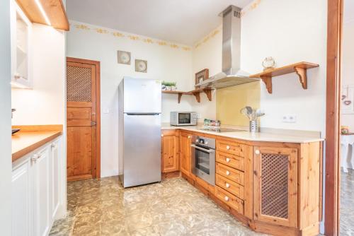 a kitchen with a stainless steel refrigerator and wooden cabinets at Can Xuri in Campos