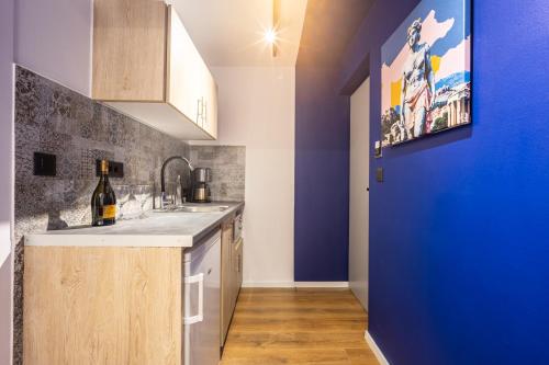 a kitchen with a sink and a blue wall at The Dorians in Athens