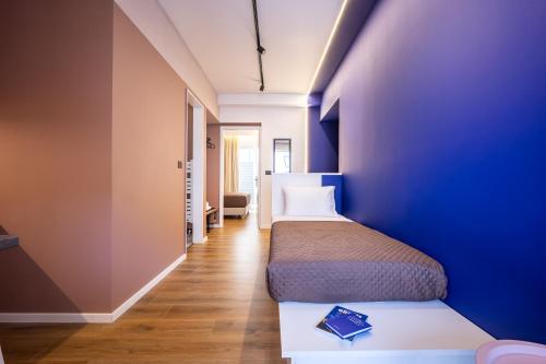 a bedroom with two beds and a blue wall at The Dorians in Athens