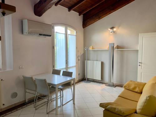 a dining room with a table and chairs and a refrigerator at VILLA CAMPESTRE in Colombaro