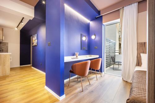 a room with blue walls and a table and chairs at The Dorians in Athens