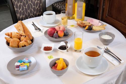 a table topped with plates of food and cups of coffee at Logis Hotel Restaurant Nougier in Saint-Étienne-de-Fursac
