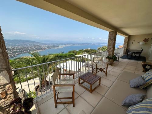 d'un balcon avec des chaises et une vue sur l'eau. dans l'établissement Maison de charme vue mer 5chambres Théoule sur mer, à Théoule-sur-Mer