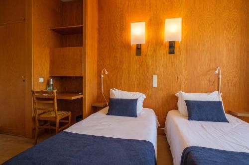 a hotel room with two beds and a desk at Vilar Oporto Hotel in Porto