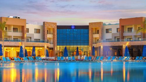 a pool in front of a hotel with chairs and umbrellas at Helnan Hotel - Port Fouad in Port Said