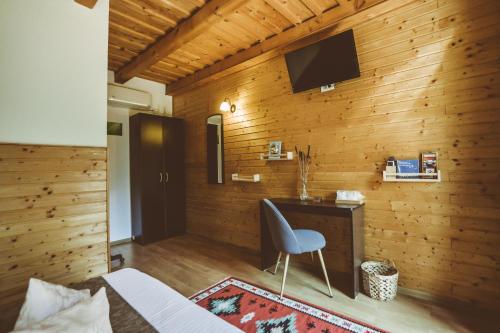 a bedroom with a desk and a tv on a wooden wall at Casa Mister in Sulina