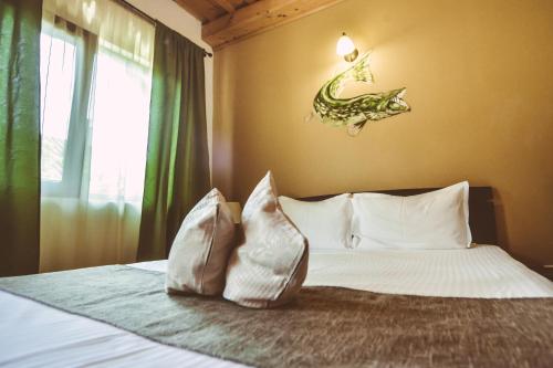 a bedroom with a bed with a fish on the wall at Casa Mister in Sulina