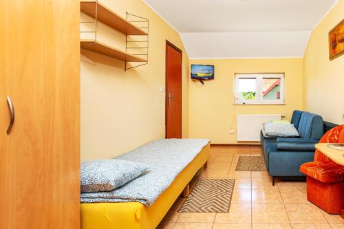 Habitación pequeña con cama y silla en Pokoje gościnne Panda en Karwia