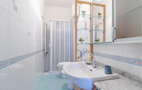 a white bathroom with a sink and a toilet at 2 Bedroom Lovely Apartment In Le Grazie in Le Grazie