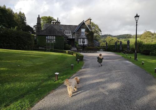 a person and a dog walking down a road at Broadoaks Boutique Country House in Windermere
