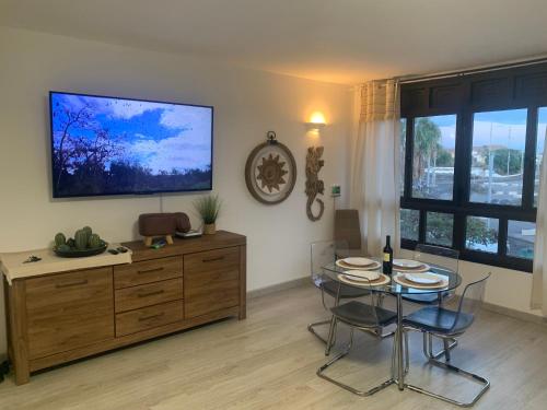 a living room with a table and a flat screen tv at Casa Susanna Apartment Costa del Silencio in Costa Del Silencio