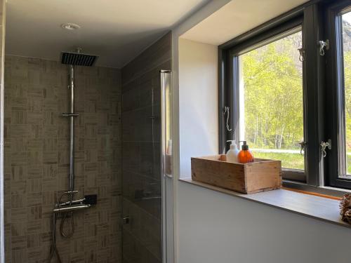 ein Badezimmer mit Dusche mit Fenster und einer Holzkiste in der Unterkunft Naturskjønt og sentralt, flott beliggende stor hytte in Fausko