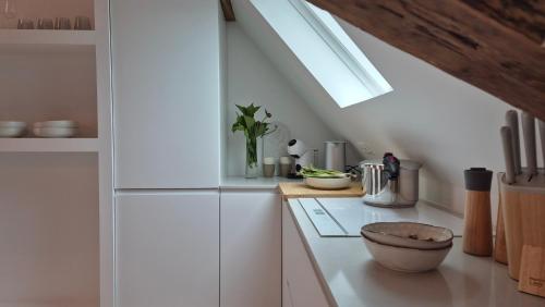 a kitchen with white cabinets and a skylight at L'Arbre Voyageur in Autun