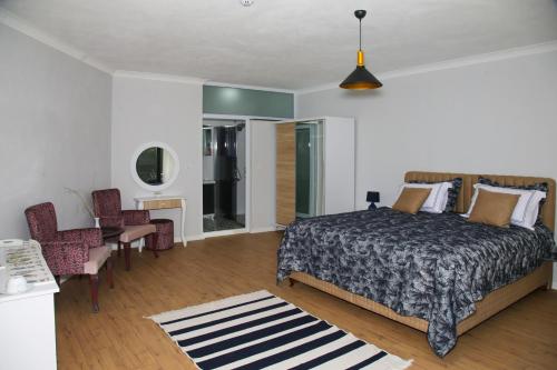a bedroom with a bed and a table and chairs at Dusler Vadisi Kazdaglari in Edremit