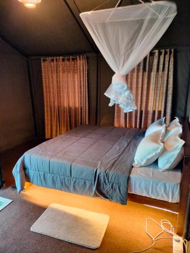 a bedroom with a bed with a mosquito net at Harmony Haven, Udawalawe, Sri Lanka in Udawalawe