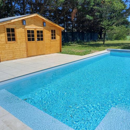 a swimming pool with a dog house next to it at Gite Moulin de Roc in Armillac