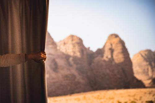 eine Person schaut aus einem Fenster auf die Wüste in der Unterkunft Wadi Rum Mirror Camp in Wadi Rum