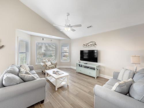 a living room with two couches and a flat screen tv at Beach Please in Surf City