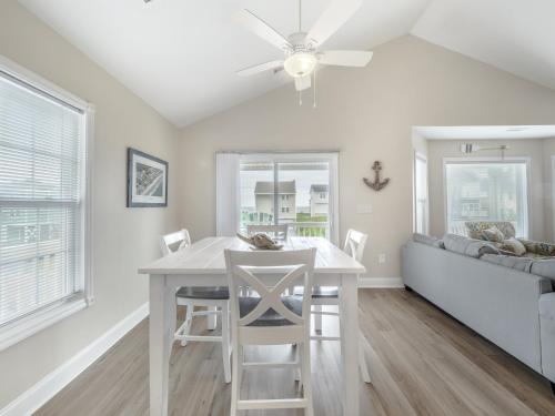 a dining room with a table and chairs and a couch at Beach Please in Surf City