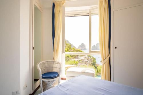 a bedroom with a bed and a large window at Villa Roccia Di Mare in Capri