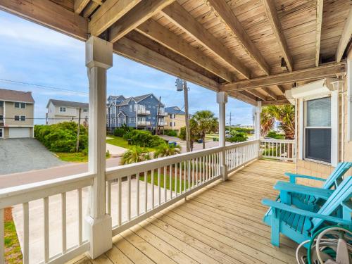 a wooden porch with a blue bench on it at Beach Please in Surf City
