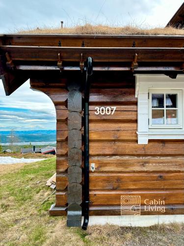 a log cabin with a straw roof at Newer lovely cabin in Birkebeinerbakken Sjusjøen in Ringsaker