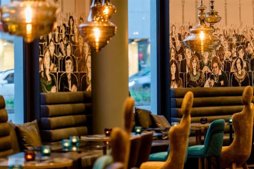 a dining room with tables and chairs and a wall mural at Motel One Bonn-Beethoven in Bonn