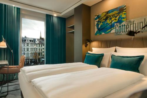 a hotel room with two beds and a window at Motel One Bonn-Beethoven in Bonn
