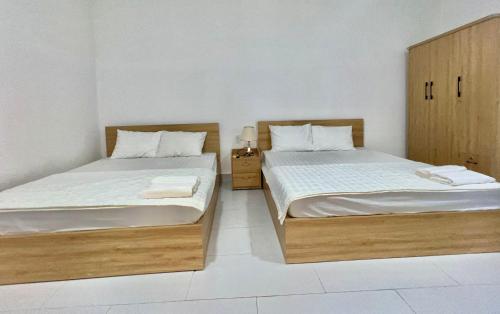 twee bedden naast elkaar in een kamer bij MARIA HOTEL in Ba Tri