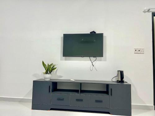 a black entertainment center with a tv on a wall at Maria Hotel in Ba Tri