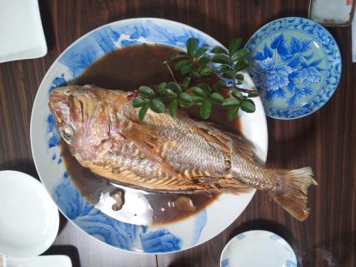 un plato de comida con un pez en una mesa en Mirai Noen, en Tanabe